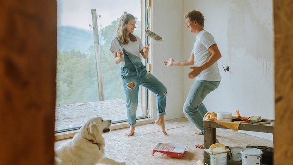 Una pareja con su perro baila en su nueva casa – Financiación de las obras