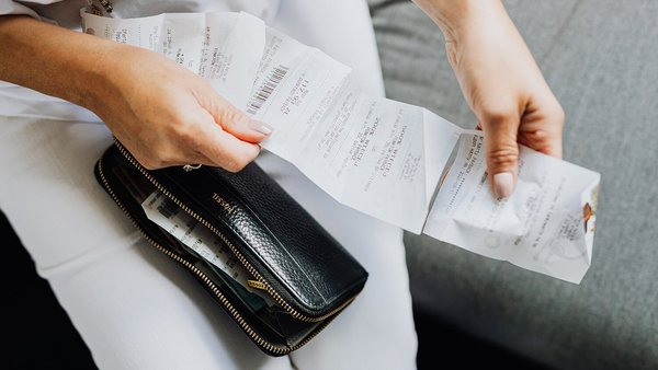 Mujer con un recibo en la mano: precios en aumento Mujer con un recibo en la mano: precios en aumento
