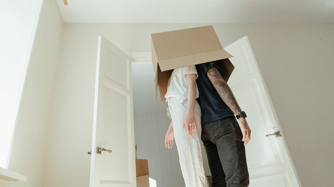 Pareja con una caja de carton haciendo la mudanza