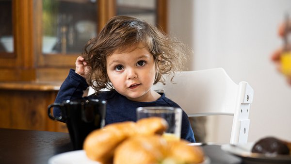 Niña en la mesa del desayuno Niña en la mesa del desayuno