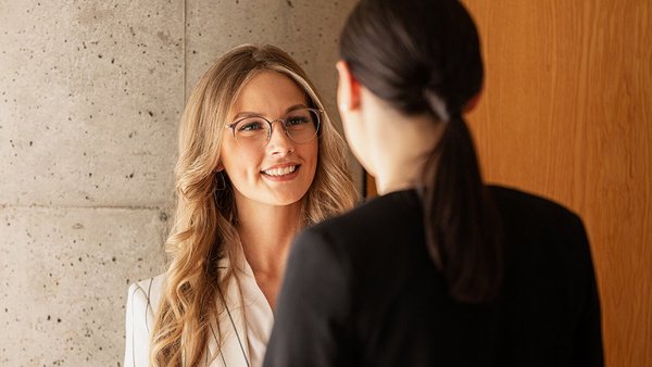 Aplica tus habilidades inmediatamente Un solicitante con gafas habla con un consultor financiero de OVB