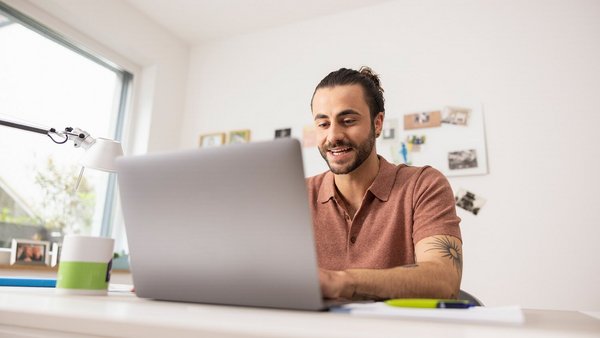 Hombre trabajando desde casa con su portátil - Oficina en casa OVB