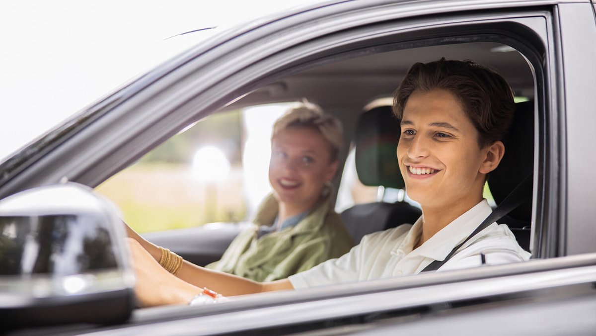 Pareja joven conduciendo un coche