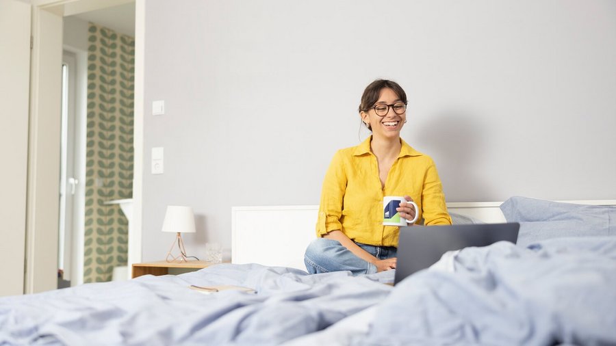 Mujer teletrabajando desde la cama