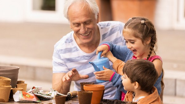 Abuelo y sus nietos plantando plantas